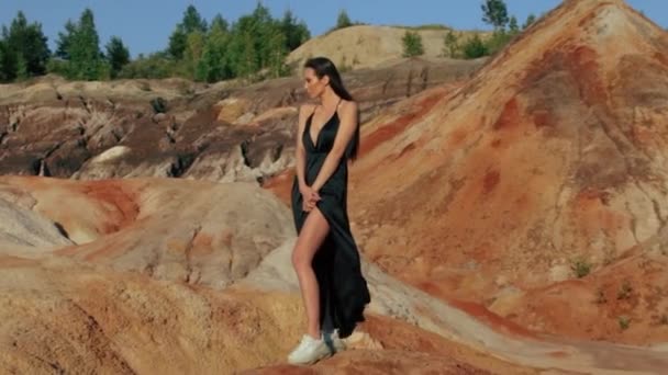 Piękna kobieta pozująca na nieziemskim pagórkowatym krajobrazie — Wideo stockowe