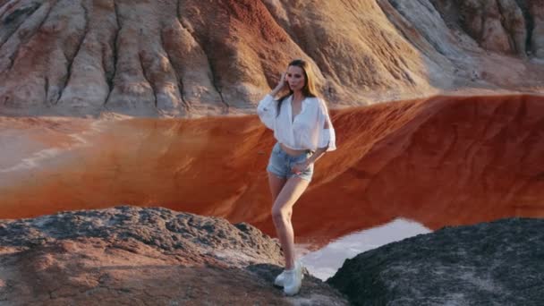 Schöne Frau posiert auf einer sonderbaren hügeligen Landschaft — Stockvideo