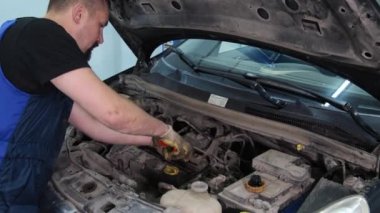 Servis merkezinde çalışan araba tamircisi.