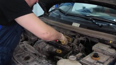 Servis merkezinde çalışan araba tamircisi.