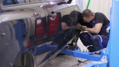 Servis merkezinde çalışan araba tamircisi.