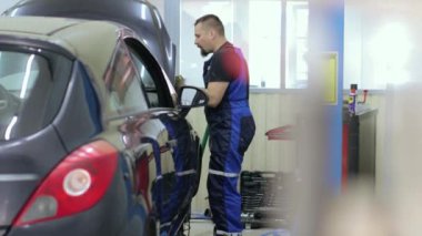 Servis merkezinde çalışan araba tamircisi.