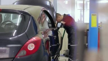 Servis merkezinde çalışan araba tamircisi.
