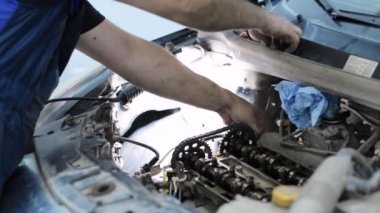 Servis merkezinde çalışan araba tamircisi.