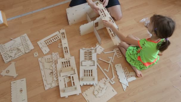 Menina com pai construindo casa de brinquedo de madeira — Vídeo de Stock