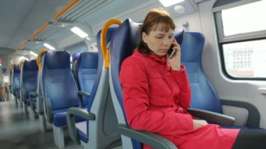 Trende cep telefonuyla konuşan kadın.