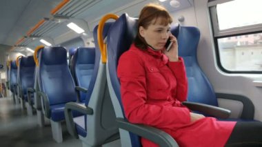 Trende cep telefonuyla konuşan kadın.