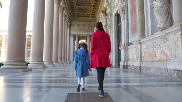 Kvinna med sin dotter går längs pelarna i basilikan Saint Paul — Stockvideo