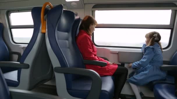 Женщина с дочерью в поезде — стоковое видео