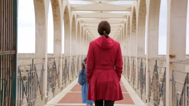 Mulher com sua filha andando sobre a ponte — Vídeo de Stock