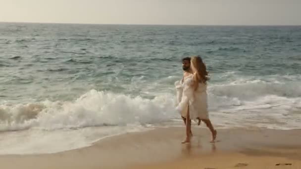Молодая красивая пара на пляже в одеялах — стоковое видео