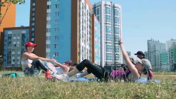 Женщины делают упражнения на животе на открытом воздухе — стоковое видео