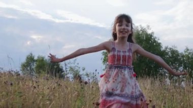 Küçük kız yaz tarlasında koşuyor.