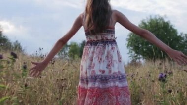 Küçük kız yaz tarlasında yürüyor