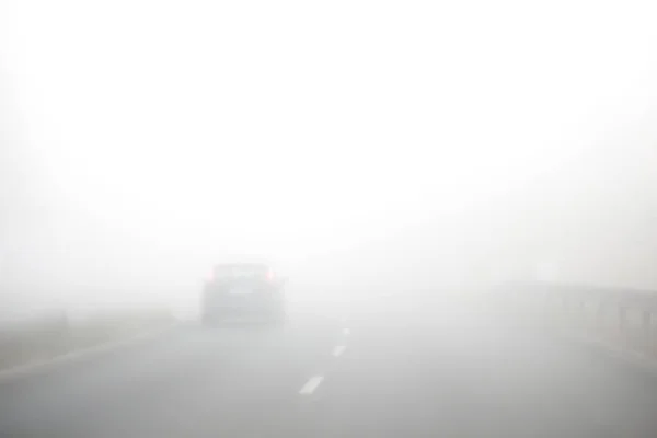 濃霧の道に 車はゆっくり運転しています 短い可視性 ストックフォト