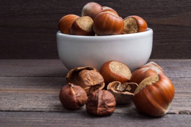 Ahşap arka plan üzerinde beyaz porselen kase Fındık fındık