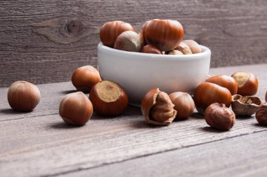 Ahşap arka plan üzerinde beyaz porselen kase Fındık fındık