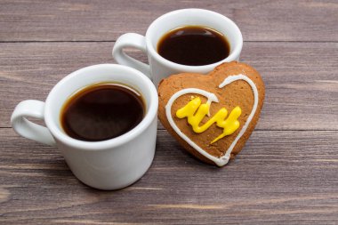 İki bardak kahve ve Sevgililer Günü'nde kalp kurabiye ahşap bir masa üzerinde