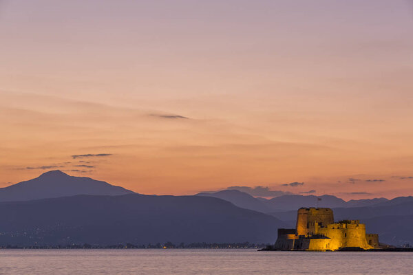 Evening view of Bourtzi fortress with mountains in the background in Nafplio