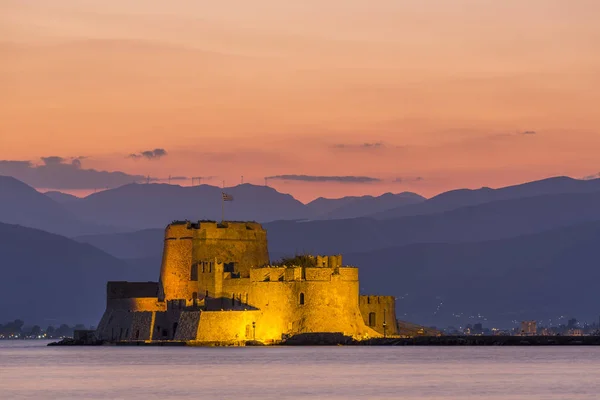 Vista nocturna de la fortaleza de Bourtzi con montañas en el fondo en Nafplio — Foto de Stock