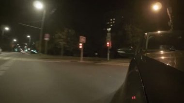 Şehrin bir yaz gecesi cadde boyunca araba taşır. Başlık üzerinden önden görünüm.