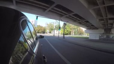 Semt güneşli yaz gününde cadde boyunca araba taşır. Araba vücut yan görünüm.