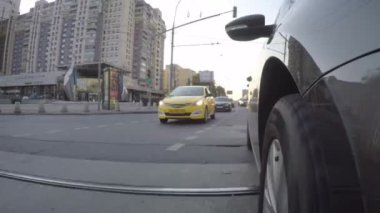 Semt güneşli yaz gününde cadde boyunca araba taşır. Araba vücut önden görünümü.