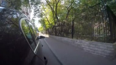 Semt güneşli yaz gününde cadde boyunca araba taşır. Araba vücut yan görünüm.