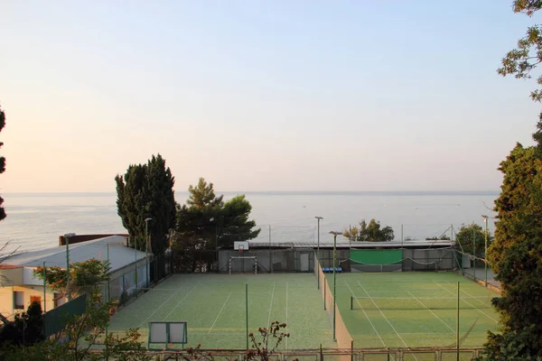 Tennis courts by the sea with green carpet — Stock Photo, Image