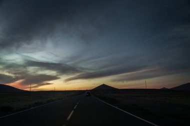 Araba yolun günbatımı siluetleri Hills Fuerteventura, Kanarya Adaları, İspanya ile sürüş.