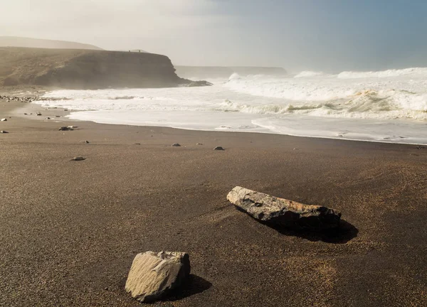 西班牙加那利群岛富埃特文图拉岛民黑色火山海滩上的岩石洗涤 — 图库照片