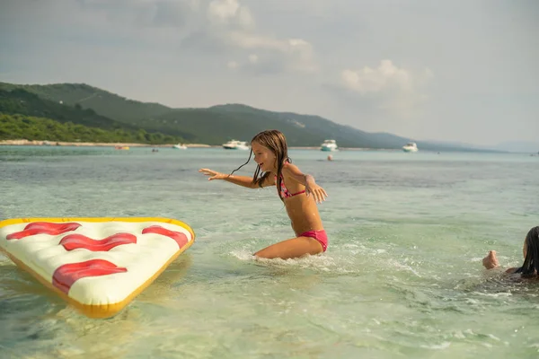 Giovane Ragazza Che Salta Sul Materasso Gonfiabile Della Pizza Mare — Foto Stock