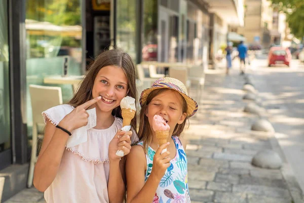 两个年轻女孩在海边边散步吃冰淇淋 — 图库照片