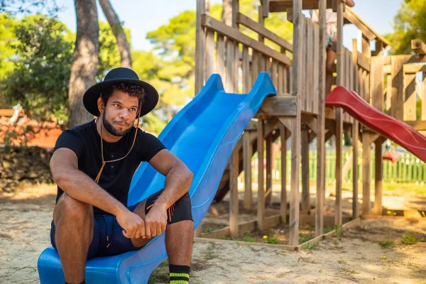 Jovem Afro Americano Sentado Slide Parque Infantil — Fotografia de Stock