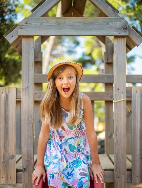 Menina Loira Bonito Com Chapéu Sentado Slide Parque Infantil — Fotografia de Stock