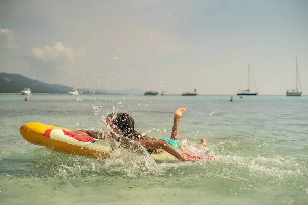 在海滩上跳上充气比萨饼床垫的年轻女孩 — 图库照片