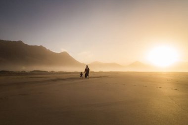 Siluet bir anne ile küçük çocuğunu Cofete, Fuerteventura, Kanarya Adaları, İspanya bir yaz gününde.