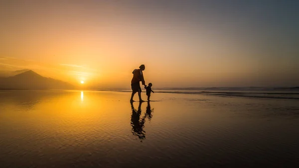 西班牙加那利群岛富埃特文图拉的科费特 年轻的母亲儿子在反射的海滩上行走的剪影 — 图库照片