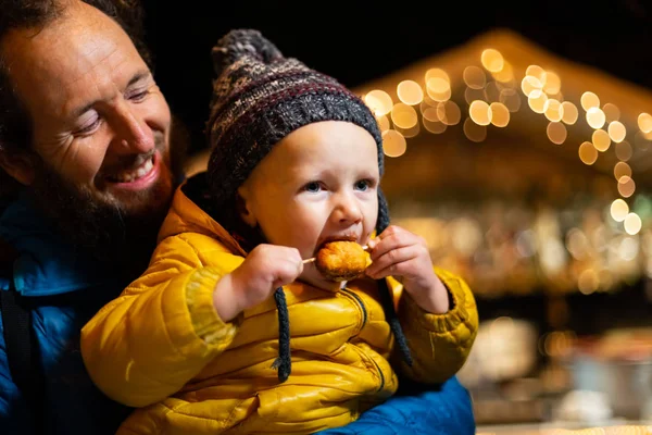 Padre Sosteniendo Hijo Mientras Disfruta Comida Tradicional Mercado Navidad —  Fotos de Stock