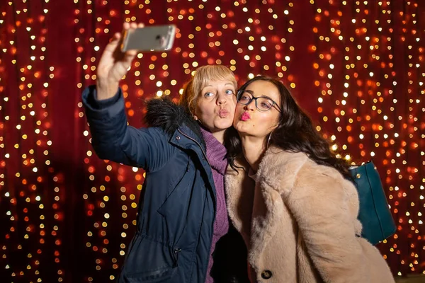 Duas Mulheres Atraentes Tirando Selfie Frente Parede Luz Mercado Natal — Fotografia de Stock