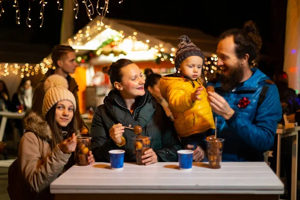 在克罗地亚萨格勒布圣诞市场享受传统美食的家庭 — 图库照片
