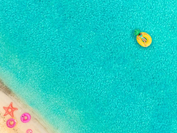 在沙滩和充气戒指上漂浮在充气菠萝床垫上的女孩鸟图 — 图库照片