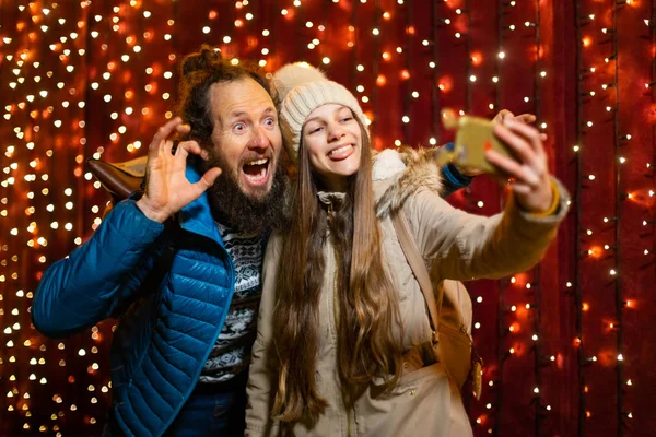 父と娘は冗談を言って クリスマス マーケットで Selfie — ストック写真