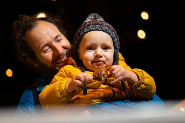 Father Holding Son While Enjoying Traditional Food Christmas Market — Stock Photo, Image