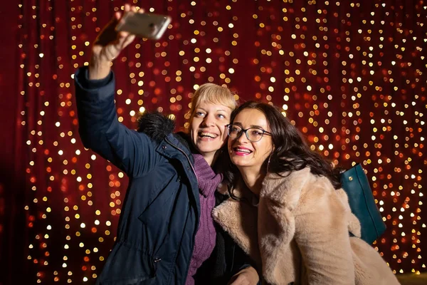 Duas Mulheres Atraentes Tirando Selfie Frente Parede Luz Mercado Natal — Fotografia de Stock