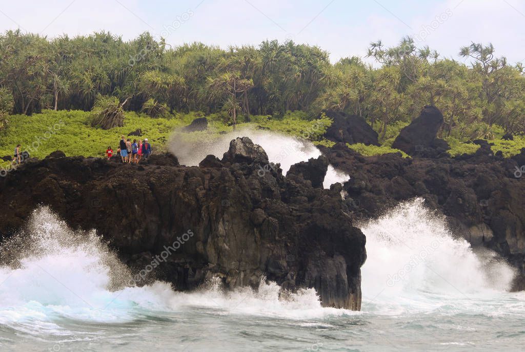 Awesome Crashing Surf Dwarfs Tourists at the Blowhole at Waianapanapa State Park, Maui, Hawaii