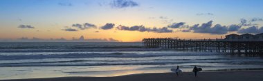 Crystal Pier, San Diego, CA günbatımı sörfçü bir çift