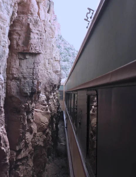 Un treno passeggeri passa pollici dalle imponenti pareti rocciose rosse — Foto Stock
