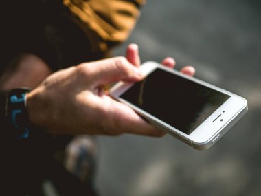 Elinde cep telefonu tutan adam