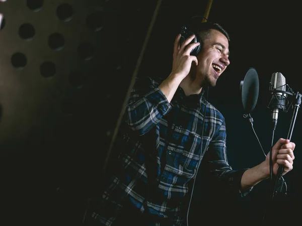 The young guy singing in recording studio